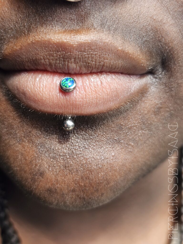 Labret lip piercing with blue opal top at Sideshow Tattoo and Piercing San Diego
