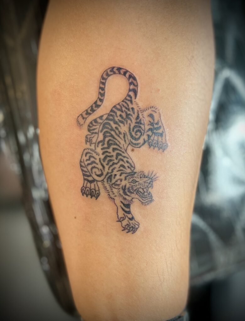 Tiger tattoo on upper arm by Sideshow Tattoo and Piercing San Diego