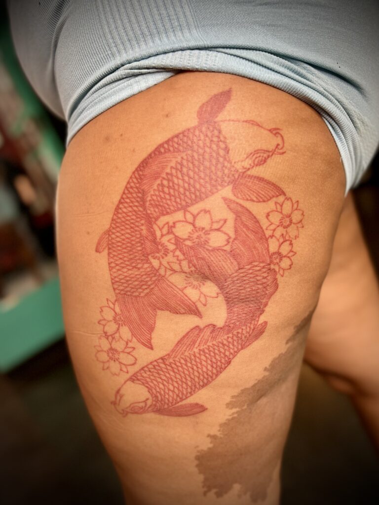 Orange koi fish tattoo on thigh by Sideshow Tattoo and Piercing San Diego
