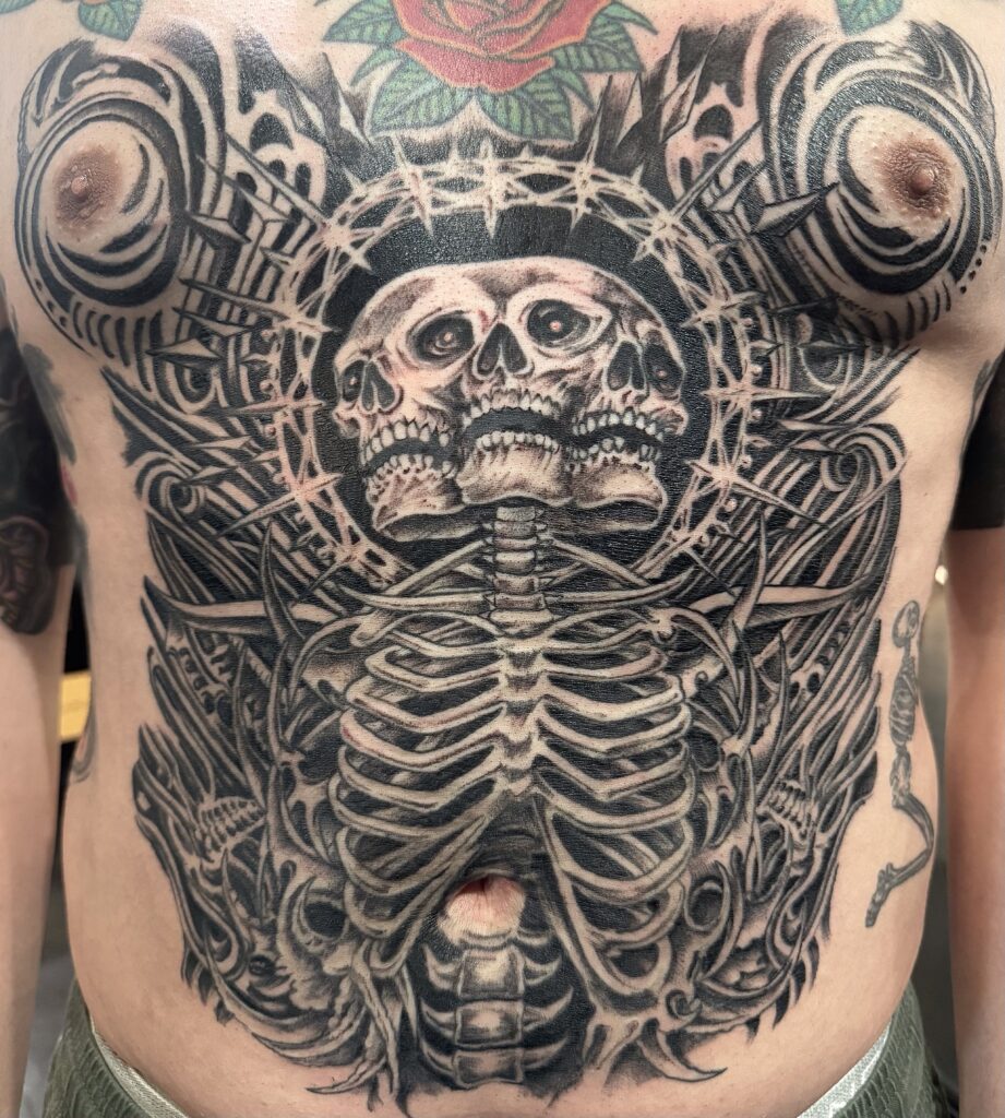 Black and grey skeleton chest tattoo by Sideshow Tattoo and Piercing San Diego